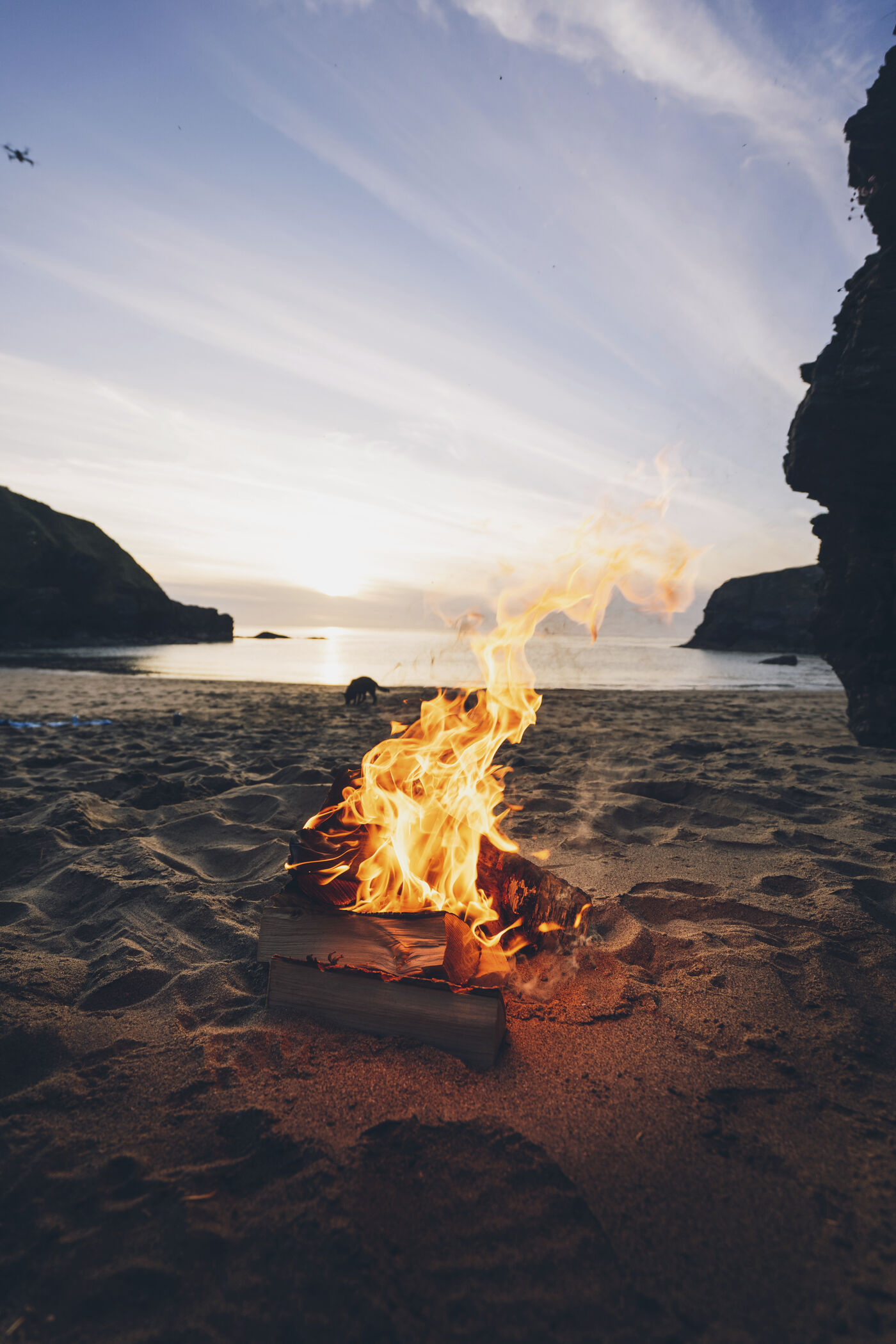A small fire on a beach at dusk