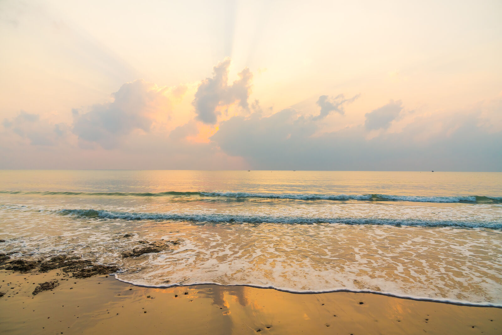 Waves washing onto a beach at sunrise